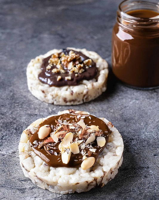 Rice cake medley topped with ShopGalil date syrup, fig preserves, chocolate spread, and nuts for a delicious Passover snack.